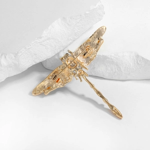 Vintage gold alloy dragonfly brooch with detailed back texture and secure rotating clasp