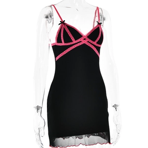 Detail of black mini dress featuring pink lace trim and crossed ribbon on the neckline