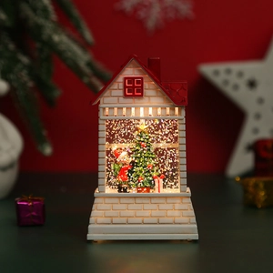 Macro shot of illuminated Christmas snow house featuring Santa and interior glitter decor