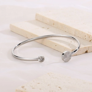Detailed view of silver C-shaped cuff bracelet with sunburst texture and zircon inlay