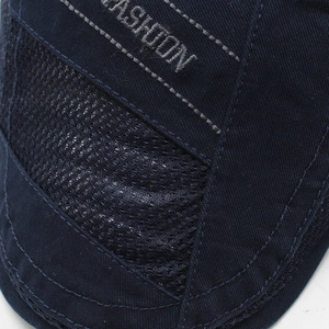 Detail of navy mesh beret showing breathable fabric and white FASHION embroidery