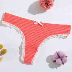 Coral red lace-trimmed ribbed cotton thong with bow accent on a clean white background