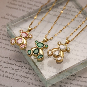 Three 18K gold plated bear necklaces with colorful zircon stones on acrylic base