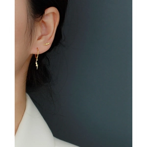 Detailed view of S925 sterling silver golden lightning bolt earrings worn on the ear lobe