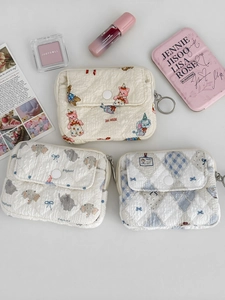 Quilted coin purses with bear and elephant prints featuring a snap pocket and zip closure
