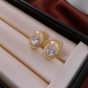 Gros plan de boucles d'oreilles clips vintage dorées avec zircon ovale et coussinets