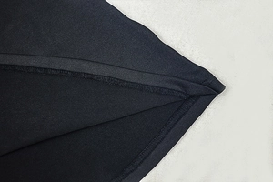 Detail shot of precise stitching and hemline on a black backless bodycon maxi dress