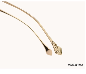 Detail shot of golden temple tips featuring an elegant feather carving design