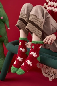 Close-up of thick coral fleece Christmas socks with snowflake patterns for winter warmth