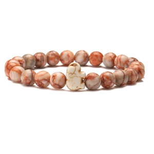 Detail of beaded stretch bracelet with brown stone beads and a white marble elephant charm