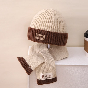 Detail of soft cream knitted winter hat and scarf set with dark brown ribbed edges