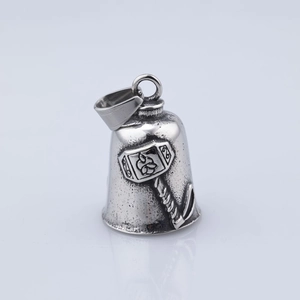 Detailed macro view of vintage silver Viking Mjolnir bell pendant with embossed carvings