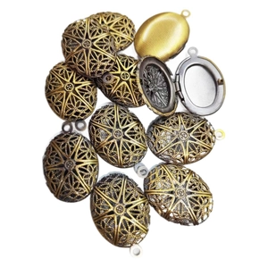 Vintage hollow oval locket pendant in antique bronze and gold finish on white background