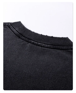 Detail of distressed crew neck on dark cotton tee showing vintage frayed edges design