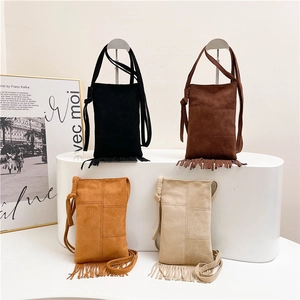 Retro oversized tote bag with long fringe in four earthy colors on display stand