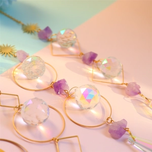 Golden crystal suncatcher with purple amethyst and rainbow prism crystals on pastel background