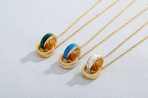 Close-up of double interlocking hoop necklaces in gold with turquoise and marble inlay