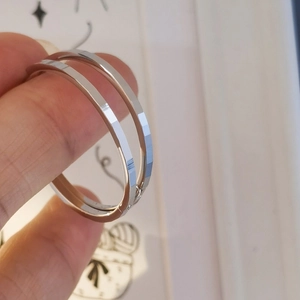 Minimalist S925 silver hoop earrings with geometric faceted texture on a model hand