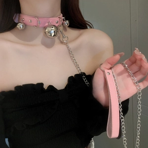 Close-up of pink leather choker featuring silver bells and a long metal leash chain