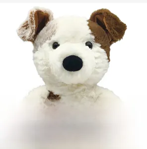 Close-up of soft plush puppy toy with fluffy white and brown fur and button eyes