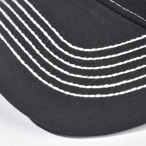 Close-up of black cotton baseball cap brim with five parallel white precision stitching