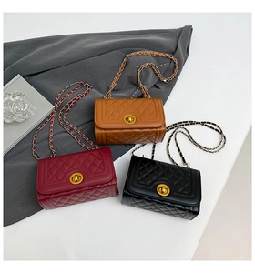 Detailed view of quilted leather small square bags in burgundy, brown and black with gold chains