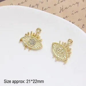 Macro shot of 21x22mm gold eye charms with sparkling crystals for DIY jewelry making