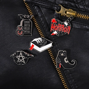 Gothic punk enamel pin set with tombstone, heart, and witch boots on black leather