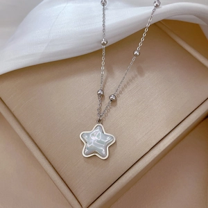 Detail shot of silver star necklace with iridescent mother-of-pearl inlay and beaded chain