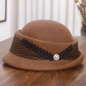 Détail du béret en laine marron avec dentelle noire, paillettes et une perle centrale