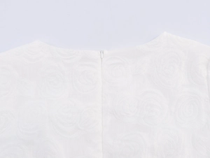 Detail of white rose jacquard fabric and invisible back zipper on an elegant mini dress