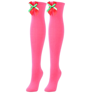Detail of pink over-knee socks with festive red and green ribbon bows on knit fabric