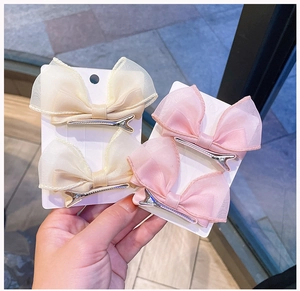 Detail of pink and beige double-layer organza bow hair clips on white display cards