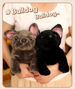 Close-up of soft plush French Bulldog dolls in grey and black held by a model