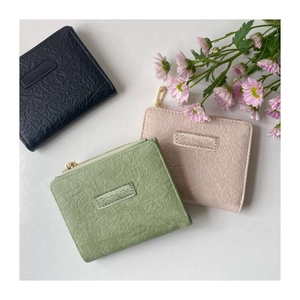 Detailed macro view of retro small wallets showing pleated leather texture and gold zippers