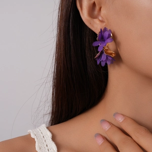 Close-up of elegant purple chiffon flower C-shaped stud earrings on a model's ear