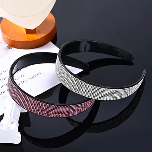 Sparkling pink and silver rhinestone headbands on reflective black background with decor