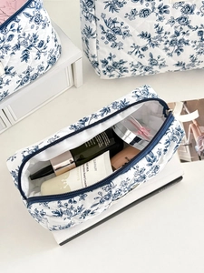 Détail de la trousse de toilette matelassée à fleurs bleues et son espace intérieur