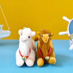 Dettaglio di portachiavi in peluche a forma di cammello bianco e marrone con piccoli campanellini