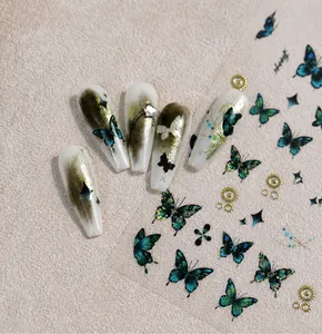 Intricate blue steampunk butterfly nail art stickers with gold foil gear details shown on nails