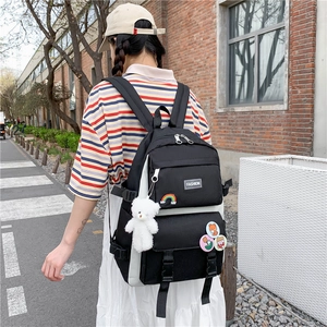 Student fashion backpack in black and white with cute plush bear and badge accessories