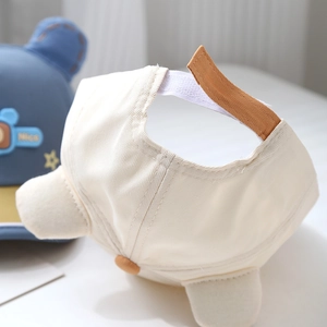 Détail de la casquette pour bébé en coton avec sangle velcro orange réglable au dos