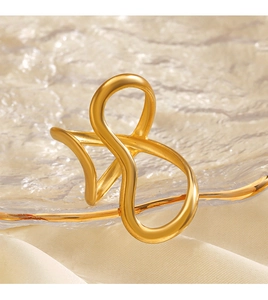 Macro shot of gold irregular wave ring on textured glass with soft fabric background