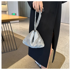 Gros plan d'un sac à main pailleté argenté montrant la texture et la forme triangle