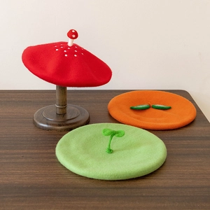 Detailed view of handmade wool felt berets in mushroom, leaf, and seedling designs