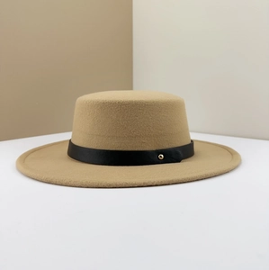 Close-up of camel wool boater hat featuring a black leather band with golden metal stud