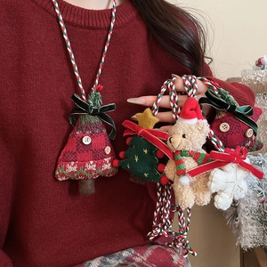 Detail of Christmas plush teddy bear and knitted tree charms on a woven necklace cord
