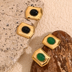 Detailed shot of retro gold rectangular earrings with green and black gemstone inlays