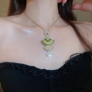 Detailed view of luxury gold necklace featuring a Pharaoh pendant with sparkling crystals