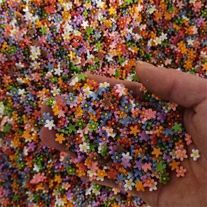 Close-up of colorful resin five-petal mini flowers for 3D nail art decoration